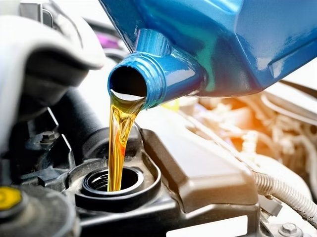 Motorolie wordt bijgevuld via de olievuldop van een motor – periodiek onderhoud van een auto